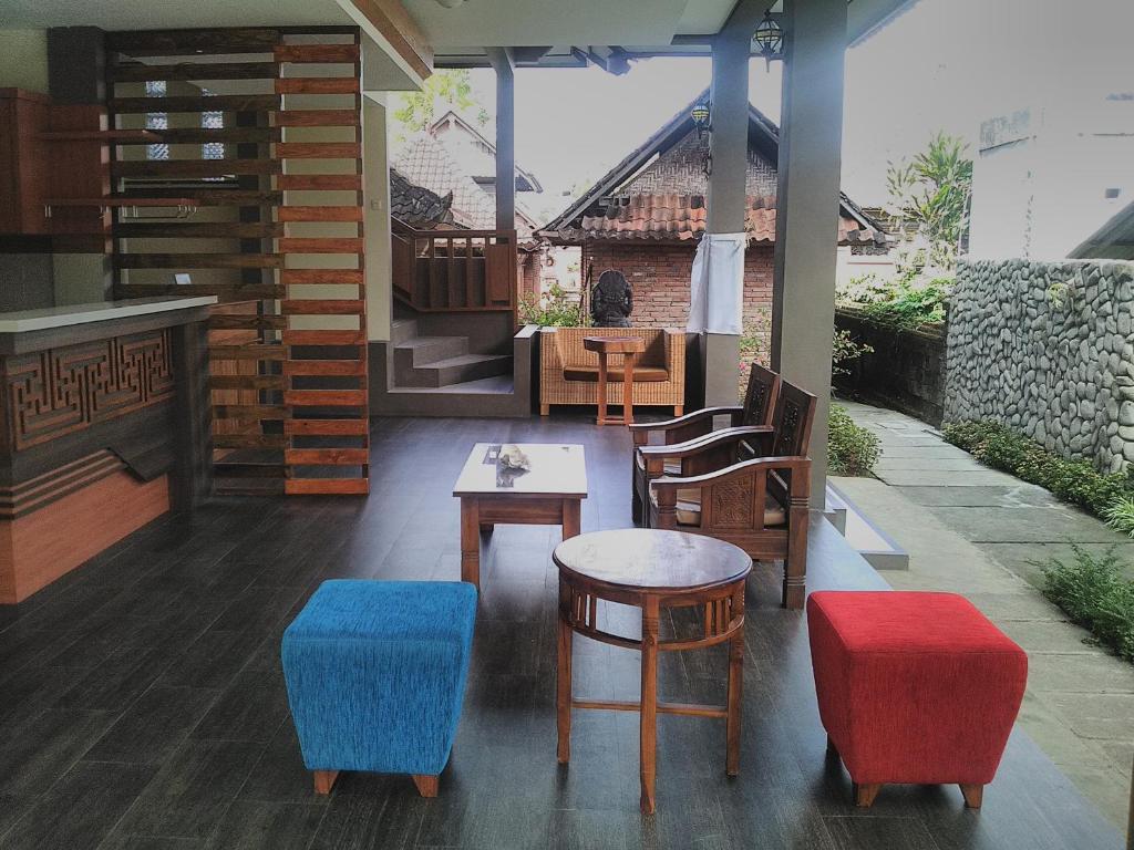 a restaurant with colorful chairs and a table at Indraprastha Ubud Home Stay in Ubud