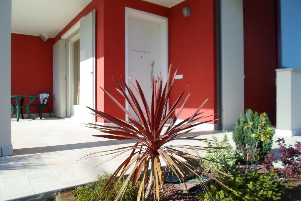 una planta frente a un edificio rojo en DIMORA Simona, en Caorle