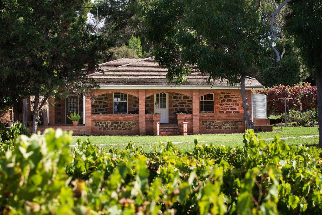 a brick house in a yard with trees and bushes at Hanisch Haus in Tanunda
