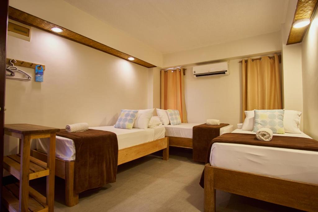 a hotel room with two beds and a table at Amakan - El Nido Palawan in El Nido