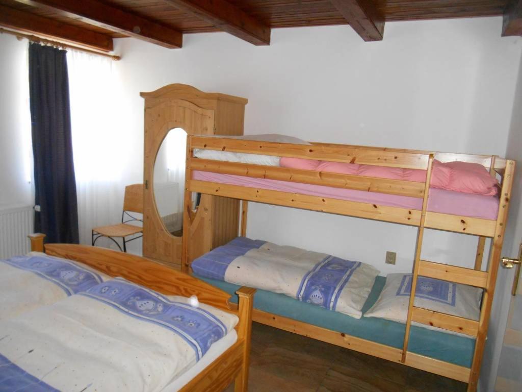 two bunk beds in a room with a mirror at Chalupa Anton in Horní Halže