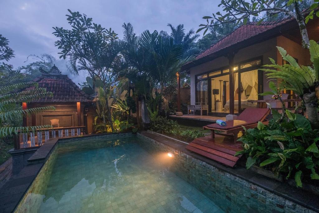 a house with a swimming pool in front of a house at Virmas Private Villa in Ubud