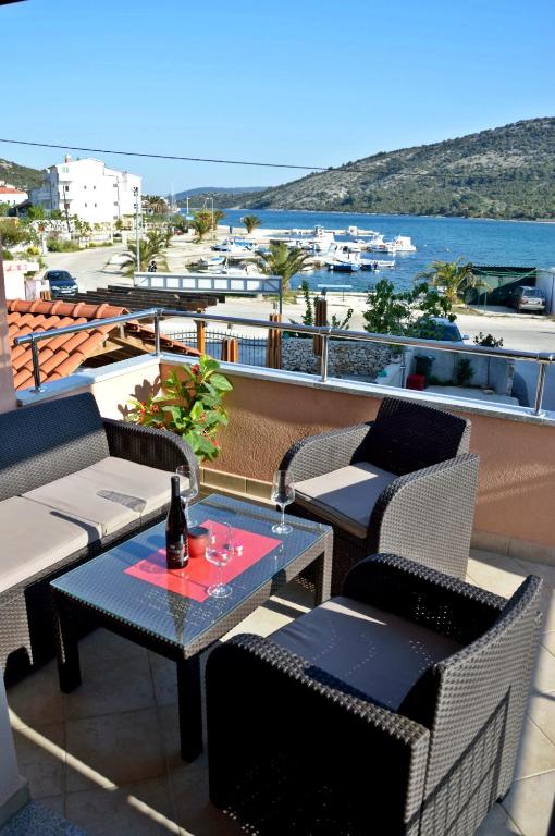 a patio with chairs and a table with a bottle of wine at Apartments Maris in Vinišće