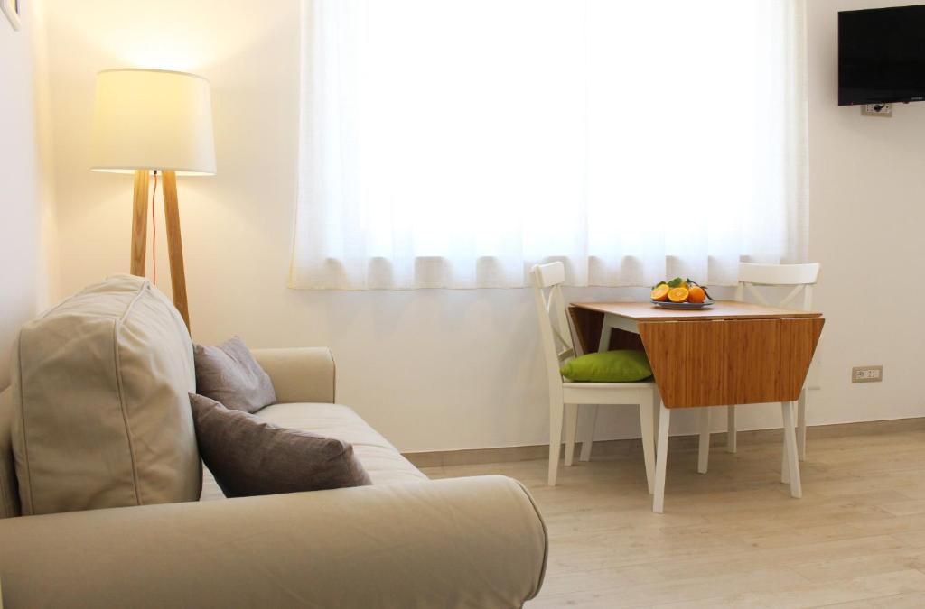 sala de estar con sofá y mesa en Taonasi Mazzeo Apartment, en Mazzeo