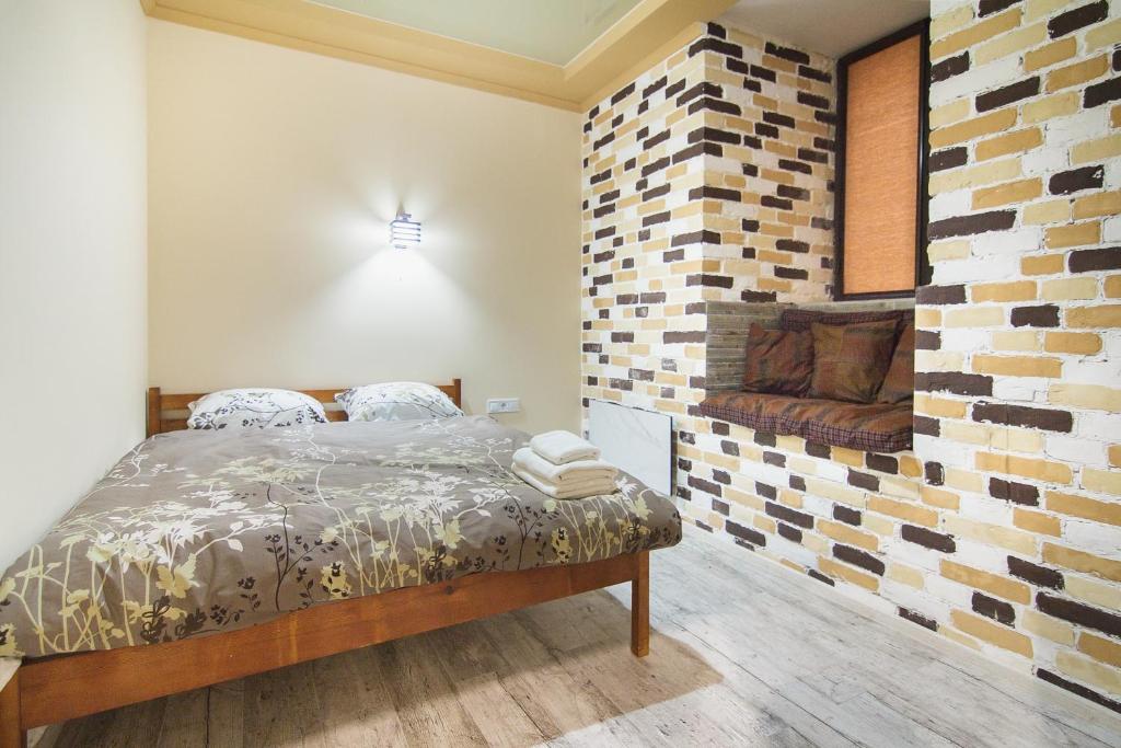 a bedroom with a bed and a brick wall at Club Suite near Deribasovskaya in Odesa