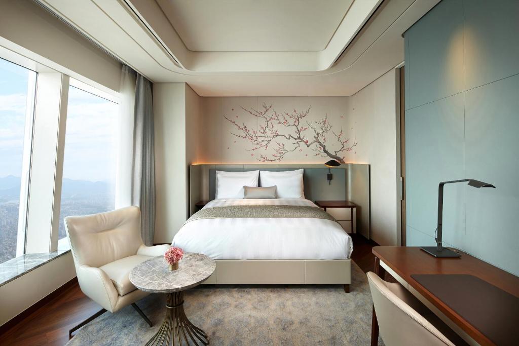 a bedroom with a bed and a desk and a chair at Signiel Seoul in Seoul