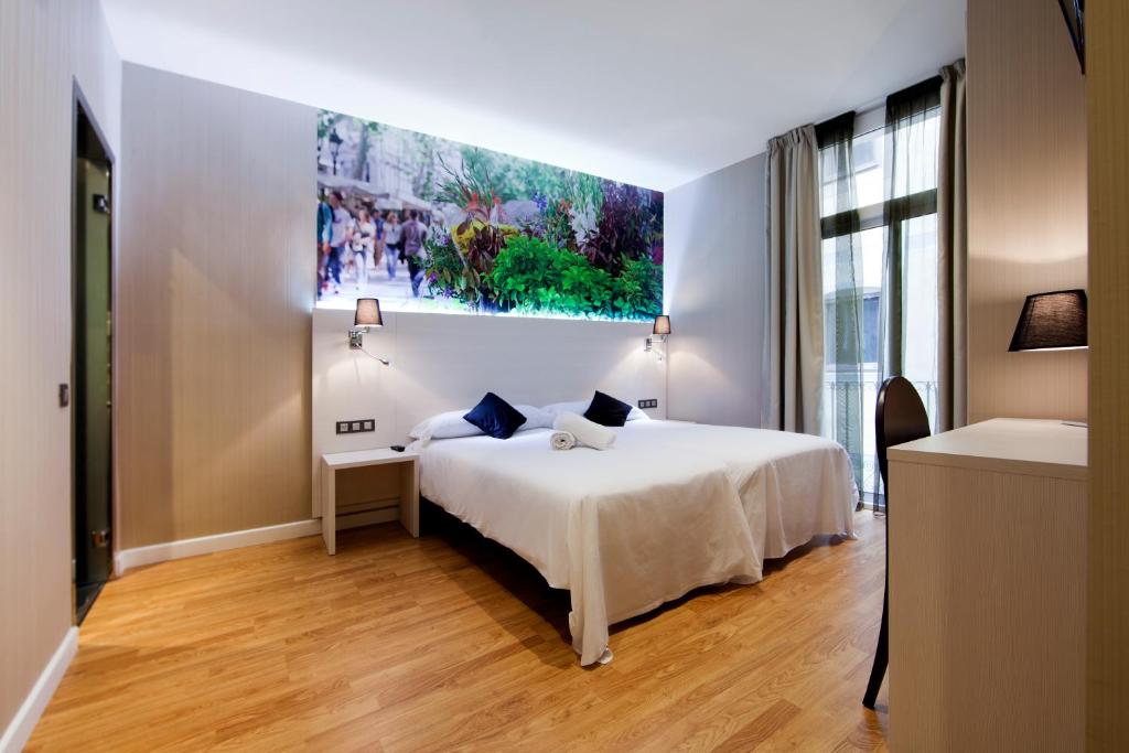 - une chambre avec un lit et une peinture murale dans l'établissement Hostal BCN Ramblas, à Barcelone