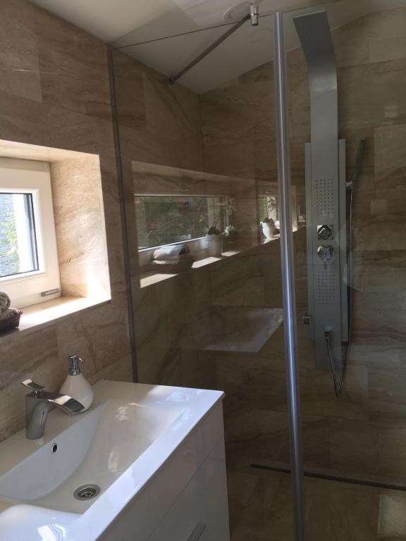 łazienka z prysznicem i umywalką w obiekcie The Lake House w mieście Fonyód