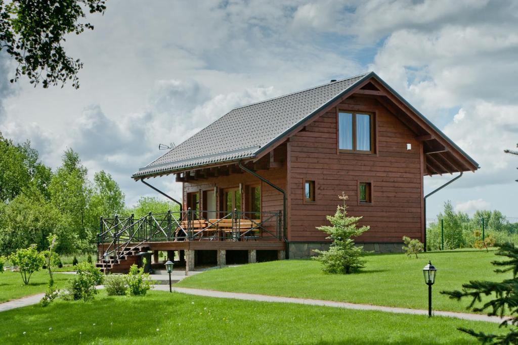 a large wooden house with a gambrel roof at Vila Viesai in Trakai