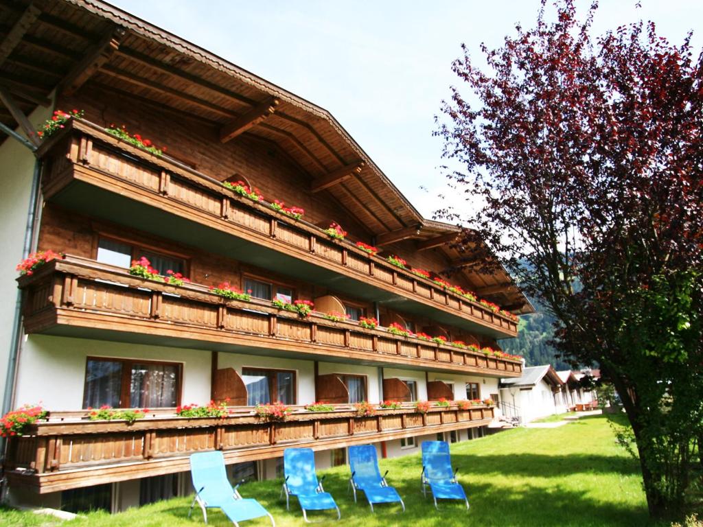 um edifício com cadeiras azuis em frente em first mountain Hotel Zillertal em Aschau