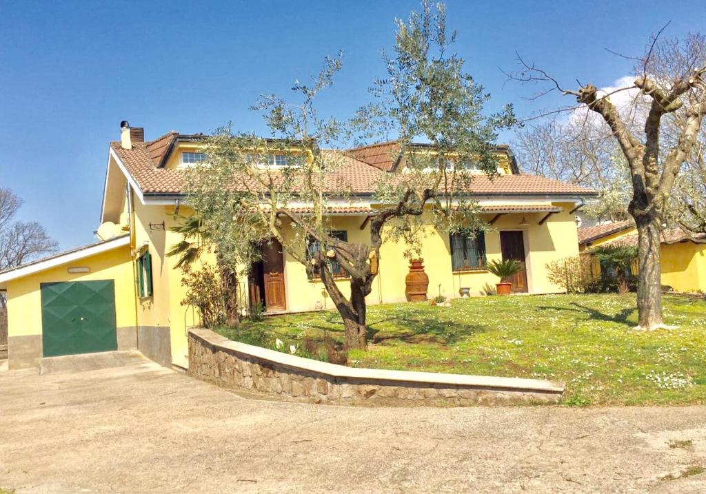 una casa amarilla con una entrada delante de ella en B & B Casal Pereto, en Valmontone