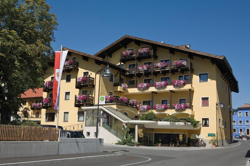 un grande edificio giallo con fioriere sopra di Hotel Zum Hirschen a Imst
