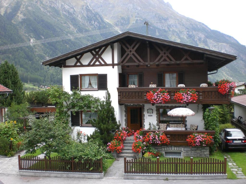 a house with flowers in front of it at Ferienwohnung Familie Höfler in Längenfeld