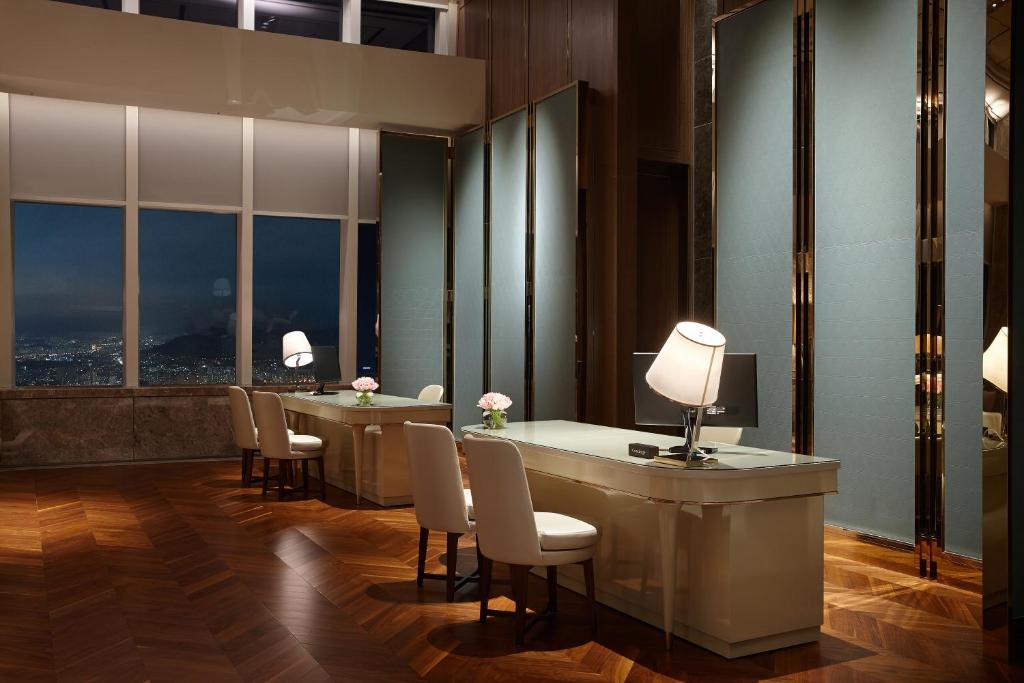 a waiting room with tables and chairs and windows at Signiel Seoul in Seoul