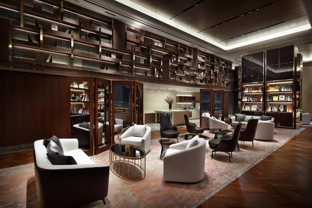 a library with couches and chairs in a room at Signiel Seoul in Seoul