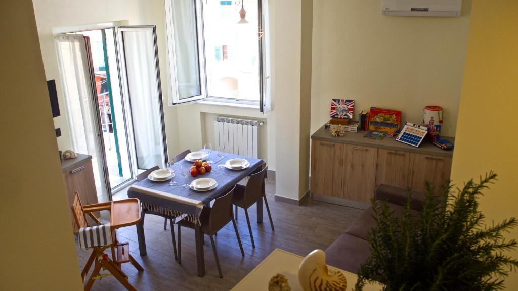 a dining room with a blue table and chairs at La Torre Apartments in Corniglia