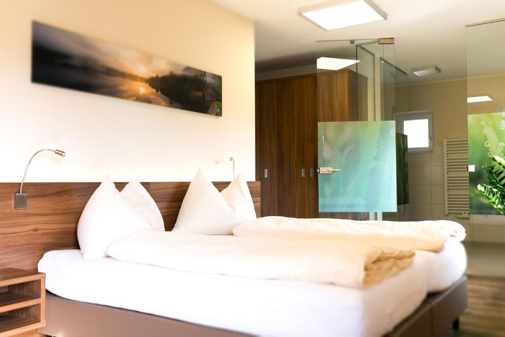 1 dormitorio con 1 cama grande con almohadas blancas en Hotel Aichingerwirt, en Mondsee