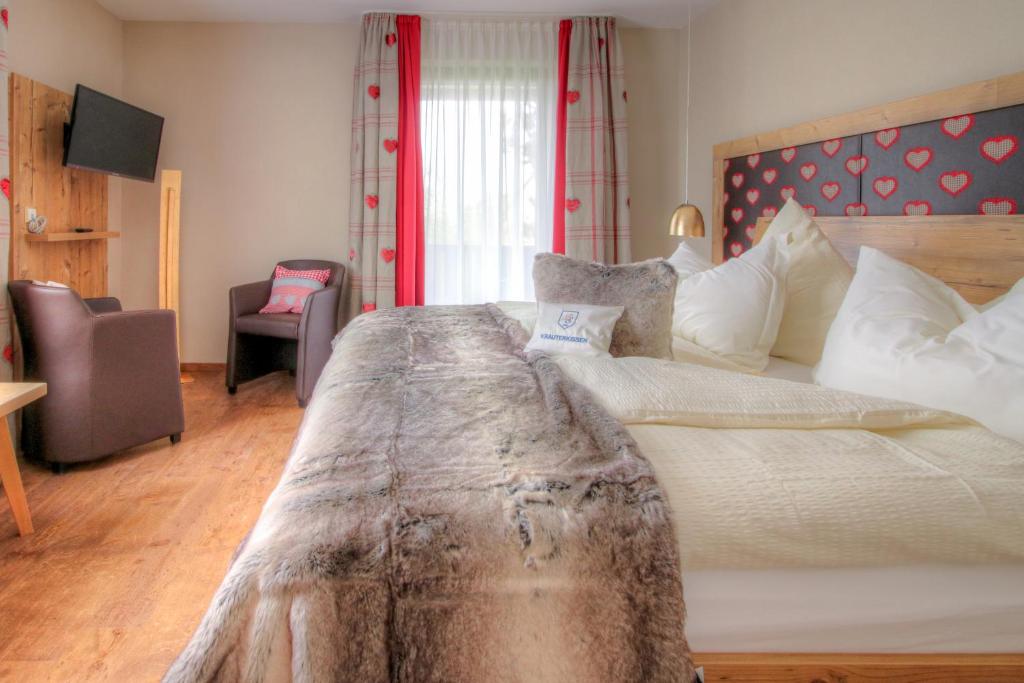 Neudrossenfeld的住宿－Landhotel Schnupp，一间卧室配有一张大床和木制床头板