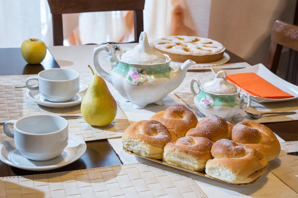 a table topped with pastries and cups and tea pots at B&B Casa Cavour in San Benedetto del Tronto