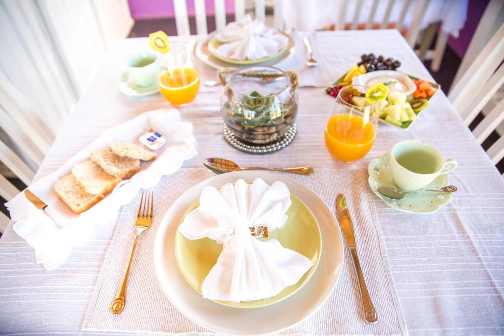 una mesa con un plato de comida y una taza de café en TshiBerry Bed & Breakfast en Phokeng