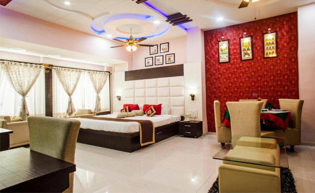 a bedroom with a bed and a table and chairs at Hotel Bhagyodaya Residency Bhilwara in Hāmīrgarh