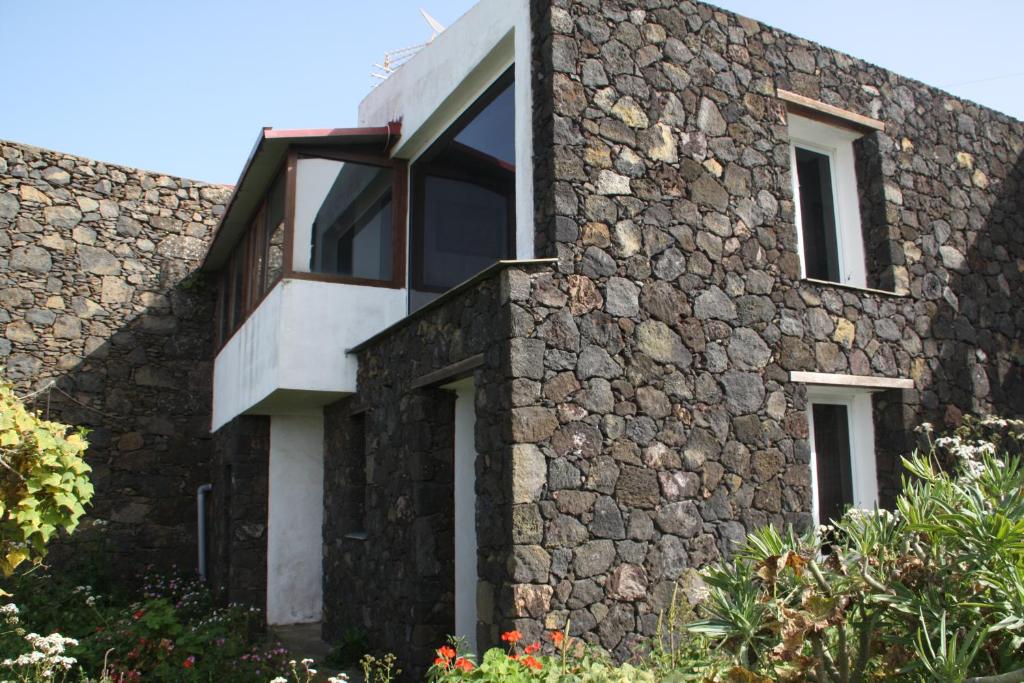 een stenen huis met ramen en een stenen muur bij Dos Violetas in Mocanal