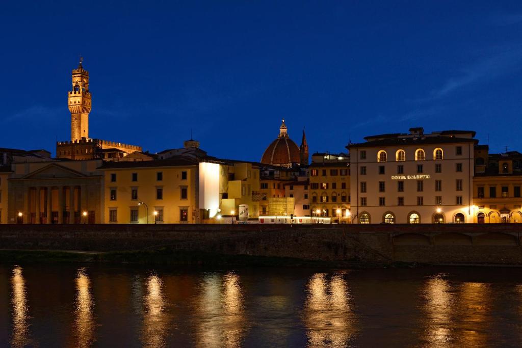 a city with a clock tower and buildings at night at Hotel Balestri - WTB Hotels in Florence