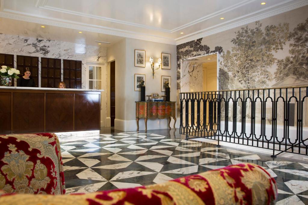 a lobby with a reception desk and a checkerboard floor at Relais Christine in Paris