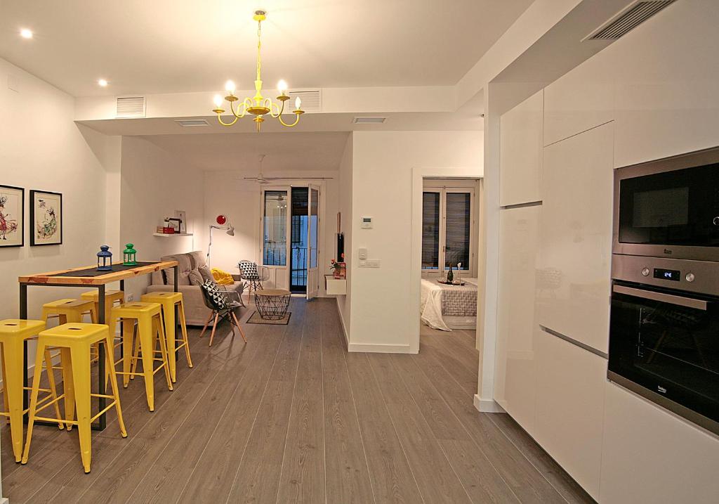 - une cuisine et un salon avec une table et des tabourets jaunes dans l'établissement Alma Calatrava, à Almagro