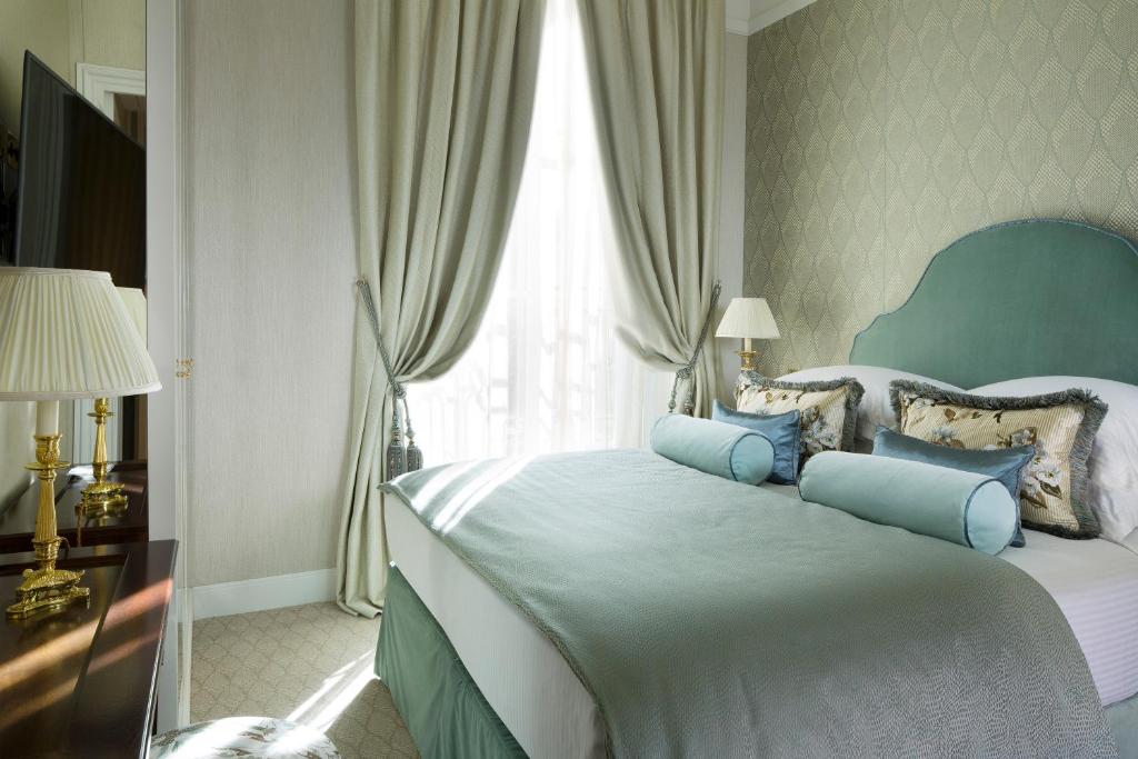 a bedroom with a large bed with blue pillows at Relais Christine in Paris