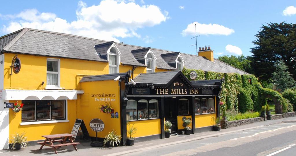 a yellow building on the side of a street at Mills Inn in Ballyvourney