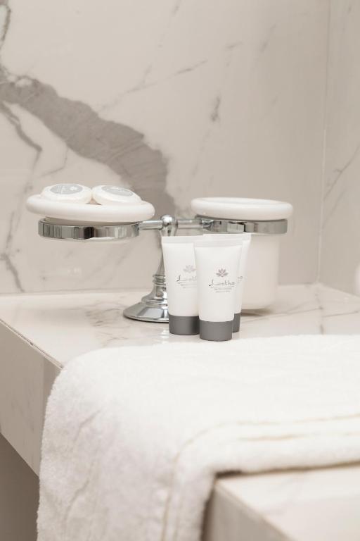 łazienka z umywalką i 2 kubkami na ladzie w obiekcie Margherita Suites w Rzymie
