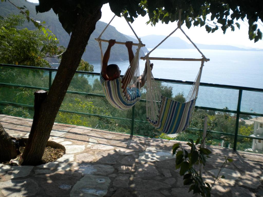a man hanging from hammocks in a tree at Theasea in Parga