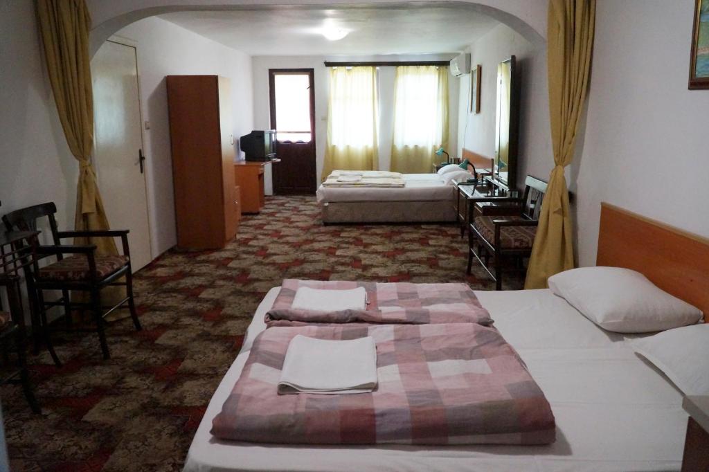ヴェリコ・タルノヴォにあるGuestrooms Rossのベッド2台とリビングルームが備わるホテルルームです。