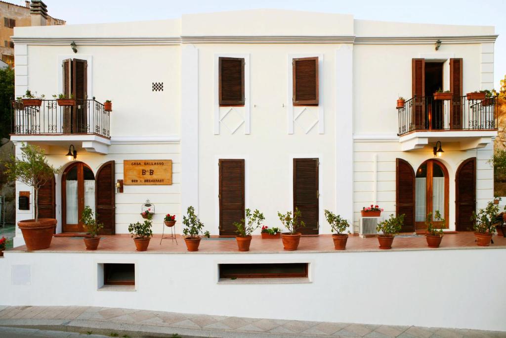 a white building with potted plants on it at Casa Gallasso in Santa Teresa Gallura