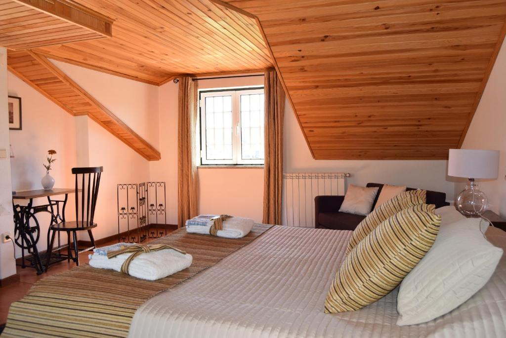 ein Schlafzimmer mit einem großen Bett und einer Holzdecke in der Unterkunft Casa do Chão do Ribeiro in Gouveia