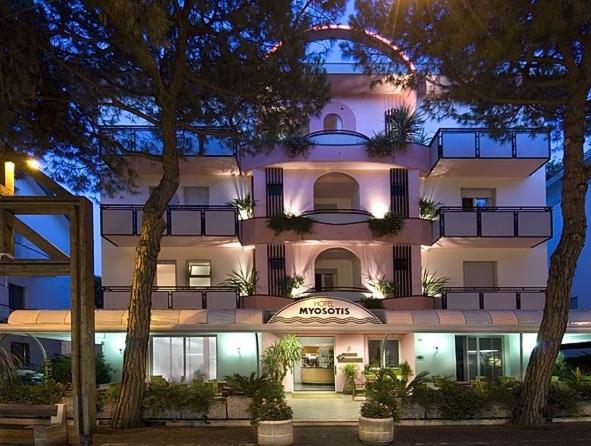 a large white building with trees in front of it at Hotel Myosotis in Riccione
