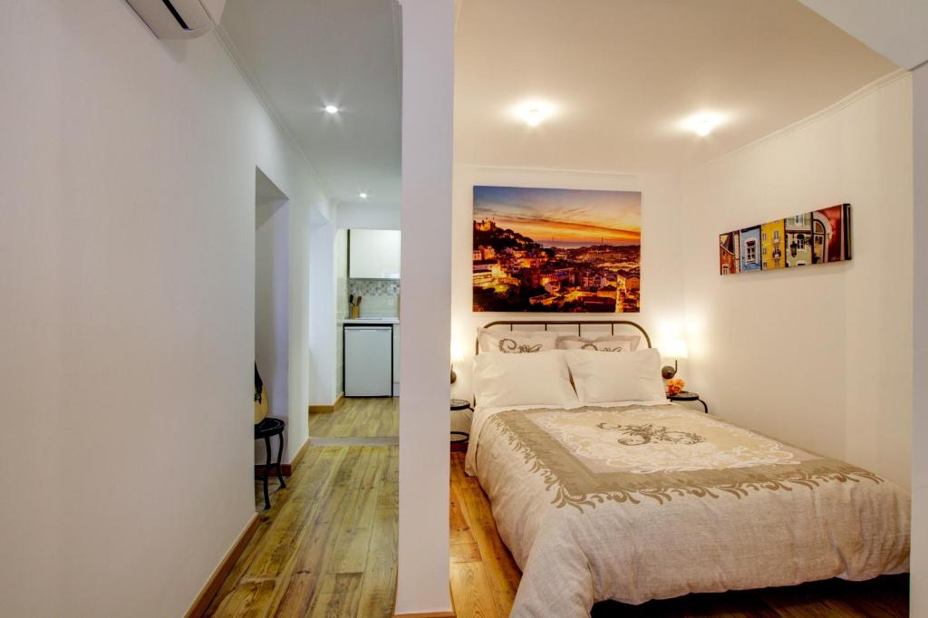 um quarto com uma cama e um quadro na parede em Cozy in the Heart of Alfama em Lisboa