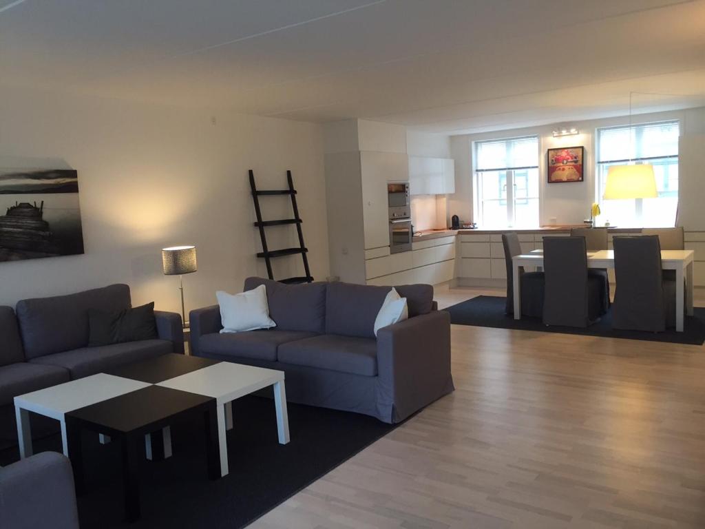 CPH Lux apartm, 2 FULL BATHROOMS 2th في كوبنهاغن: غرفة معيشة مع أريكة وطاولة