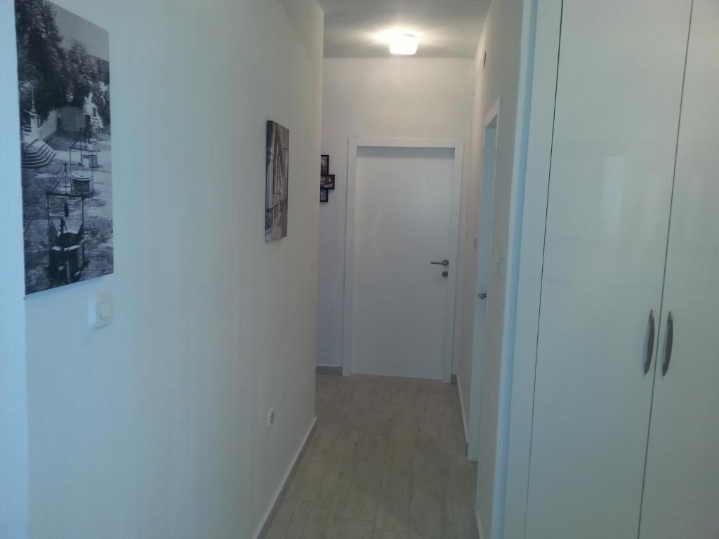 a hallway with a white door and a cross on the wall at Apartments Roncevic in Zadar