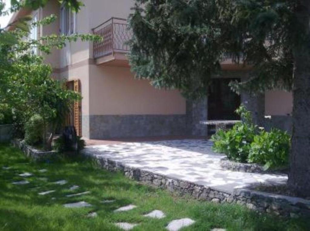 a house with a walkway in front of a yard at Casa Giardino in Spotorno