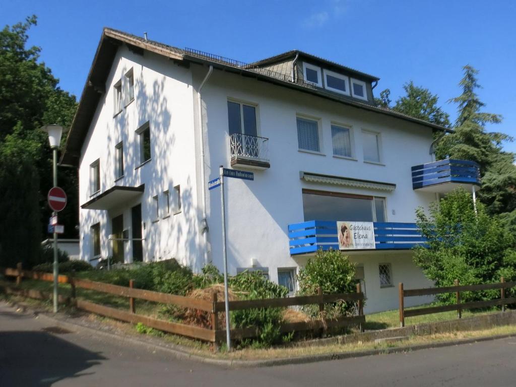 a white building with blue windows and a stop sign at Gästehaus Elena in Kassel