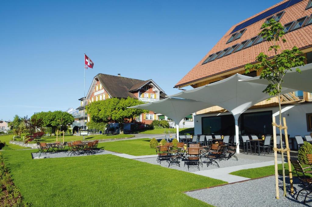 un patio con mesas y sillas frente a un edificio en Hotel Friedheim, en Weggis