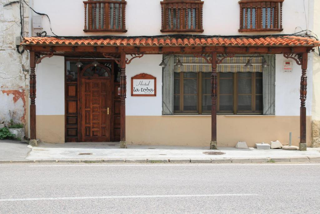 CañeteにあるHostal La Tobaの木製の扉付きの建物の入口