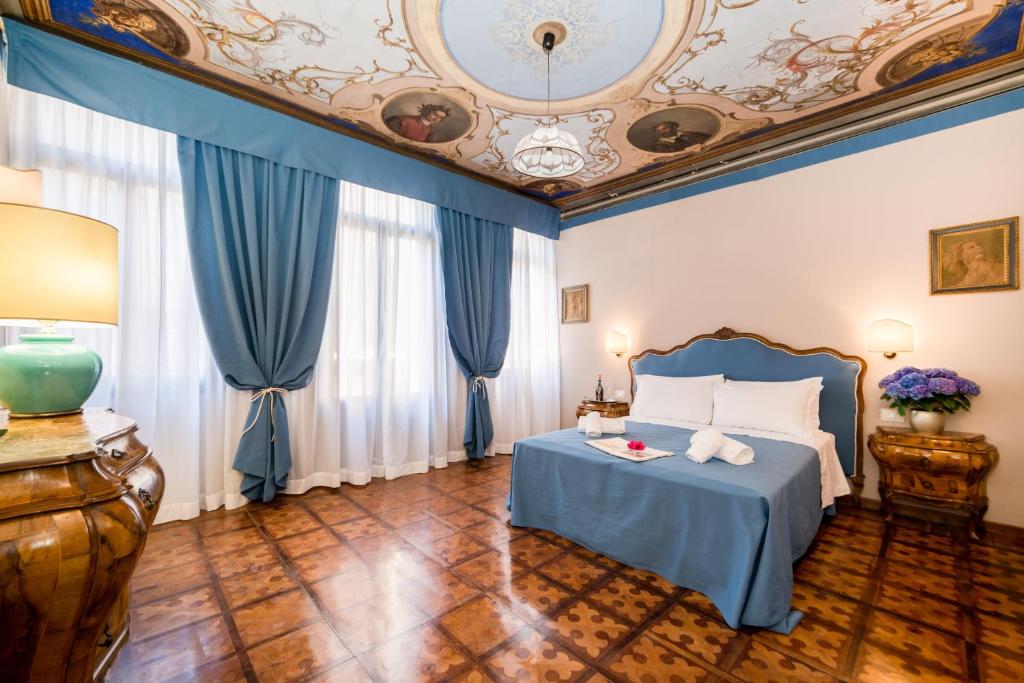 - une chambre avec un lit bleu et un plafond dans l'établissement Ca' Lavezzera, à Venise