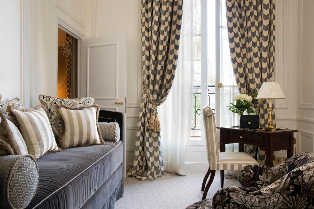 a bedroom with a bed and a desk and a window at Relais Christine in Paris