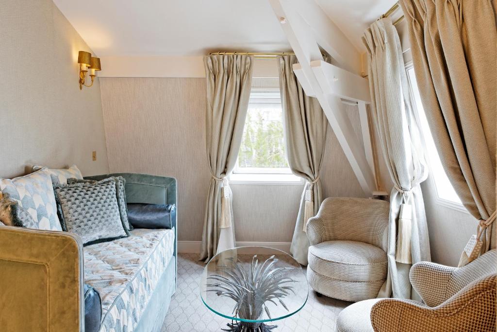 a living room with a couch and a chair at Relais Christine in Paris
