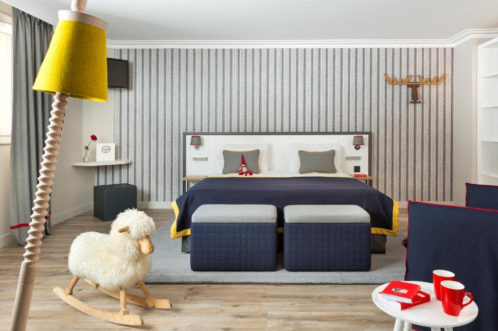 a bedroom with a bed and a stuffed sheep in front of a lamp at Araucaria Hotel & Spa in La Plagne