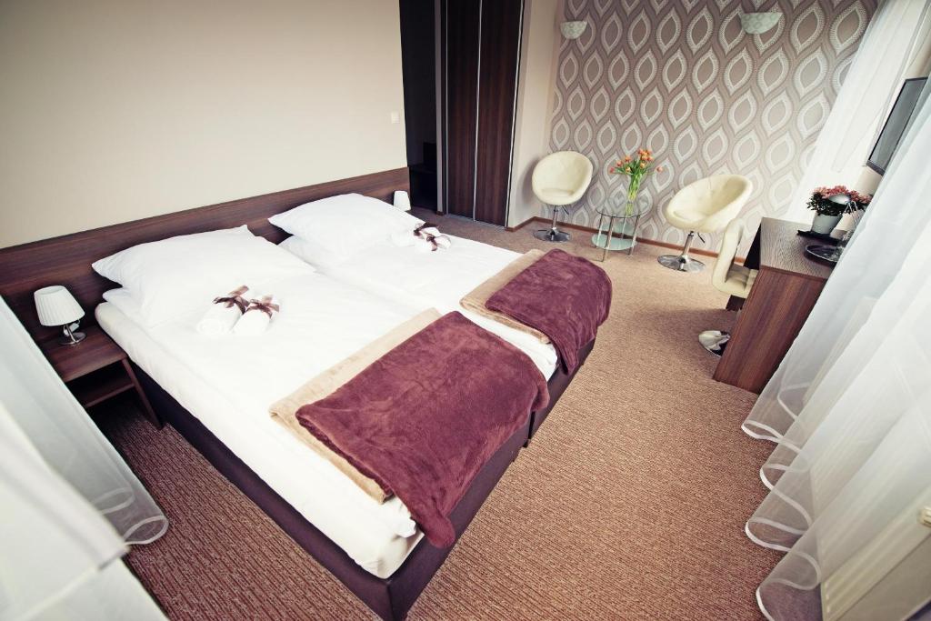 a bedroom with a bed and two chairs at Makara in Katowice