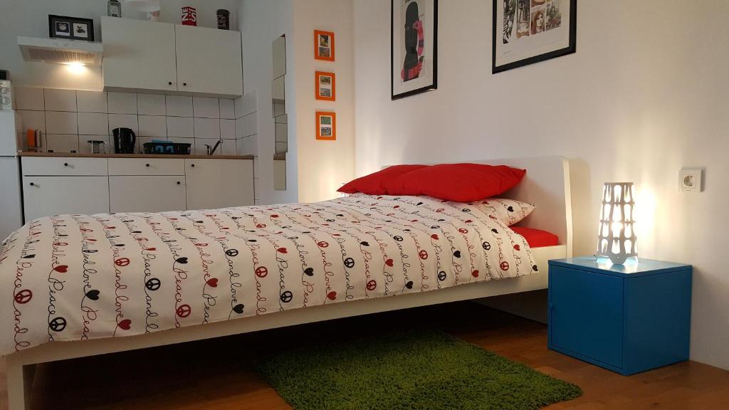 a bedroom with a bed with a red pillow and a green rug at Apartments Garden Zagreb in Zagreb